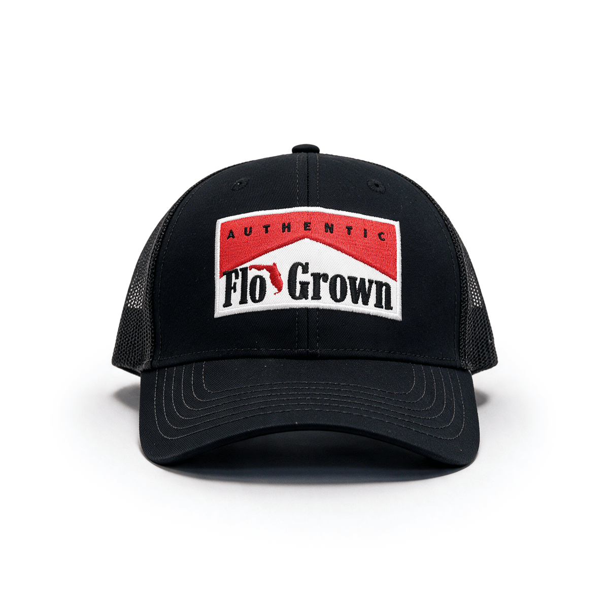 A black trucker-style cap with a curved brim and black mesh side panels, featuring a front patch that reads 'Authentic Flo Grown' in red, white, and black.