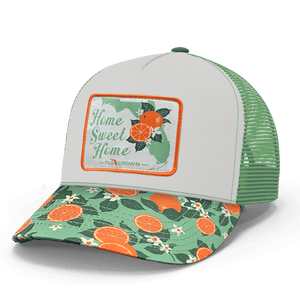 Trucker hat with floral and orange design on the visor with a white crown and a patch that says 