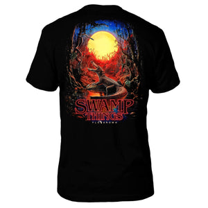 Black t-shirt with an alligator in the swamp with a full moon and red ambience and text 'SWAMP THINGS'.