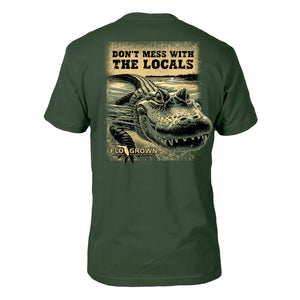 Green shirt with a graphic of an alligator in the water and text 'DON'T MESS WITH THE LOCALS'.