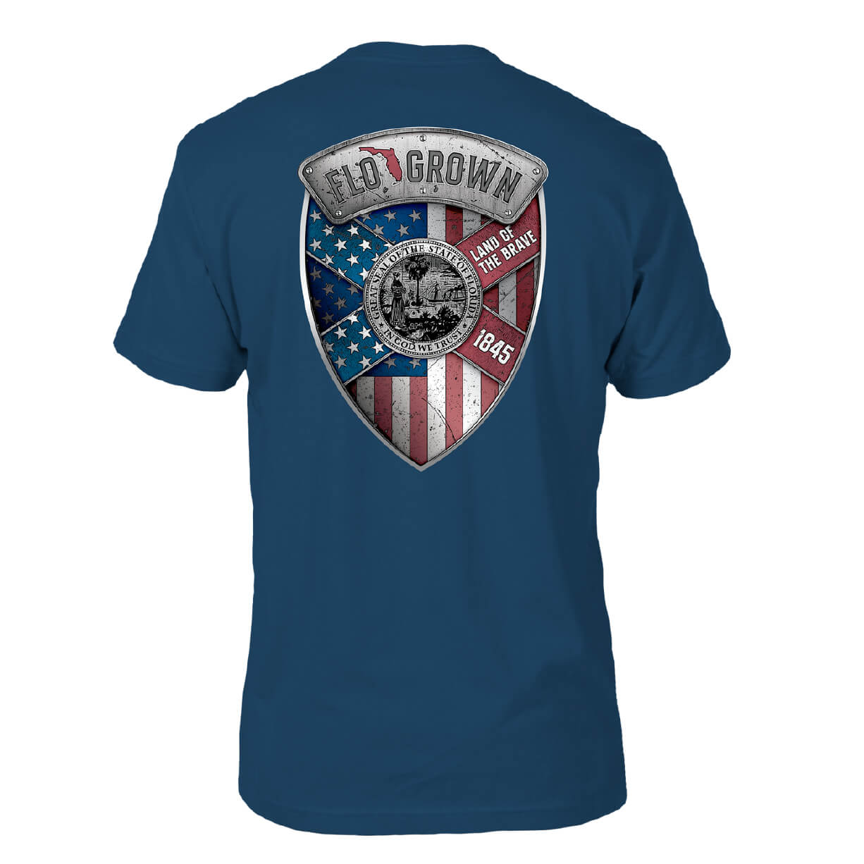 Blue shirt with a graphic in the shape of a badge on the back that features an American flag and the Florida flag with text 'LAND OF THE BRAVE - 1845'.