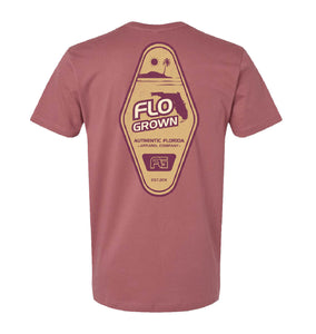 Red tee with a diamond shape design on the back featuring an island and sunset with the 'FloGrown' logo in the center.