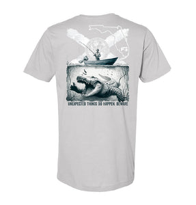 Gray t-shirt with a graphic of an alligator and a boat with text 'UNEXPECTED THINGS DO HAPPEN. BEWARE'.