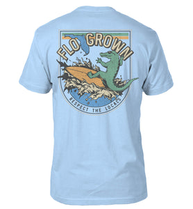 Light blue t-shirt with a graphic of an alligator surfing and the text 'RESPECT THE LOCALS'.