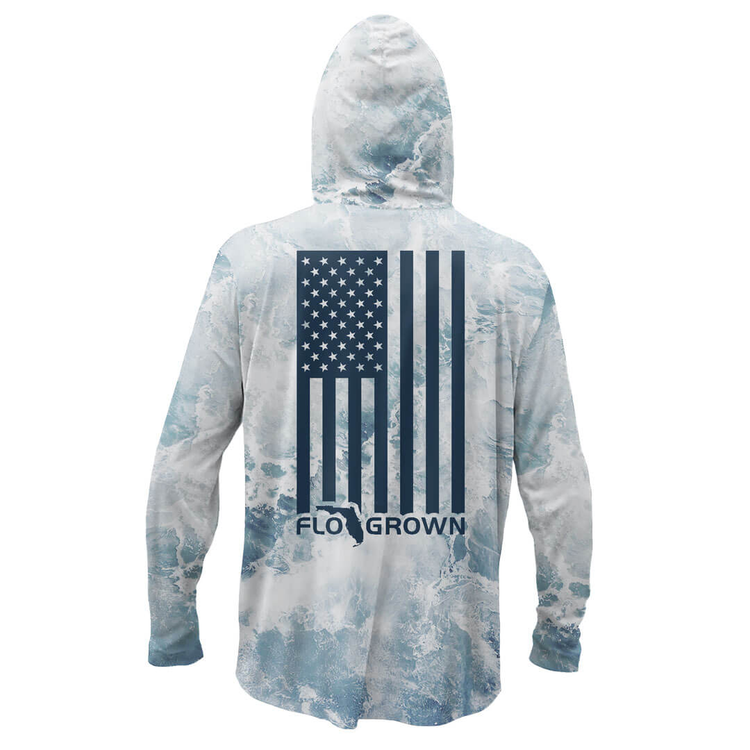 Long sleeve performance hoodie with a design of crashing waves and a vertical American flag on the back.
